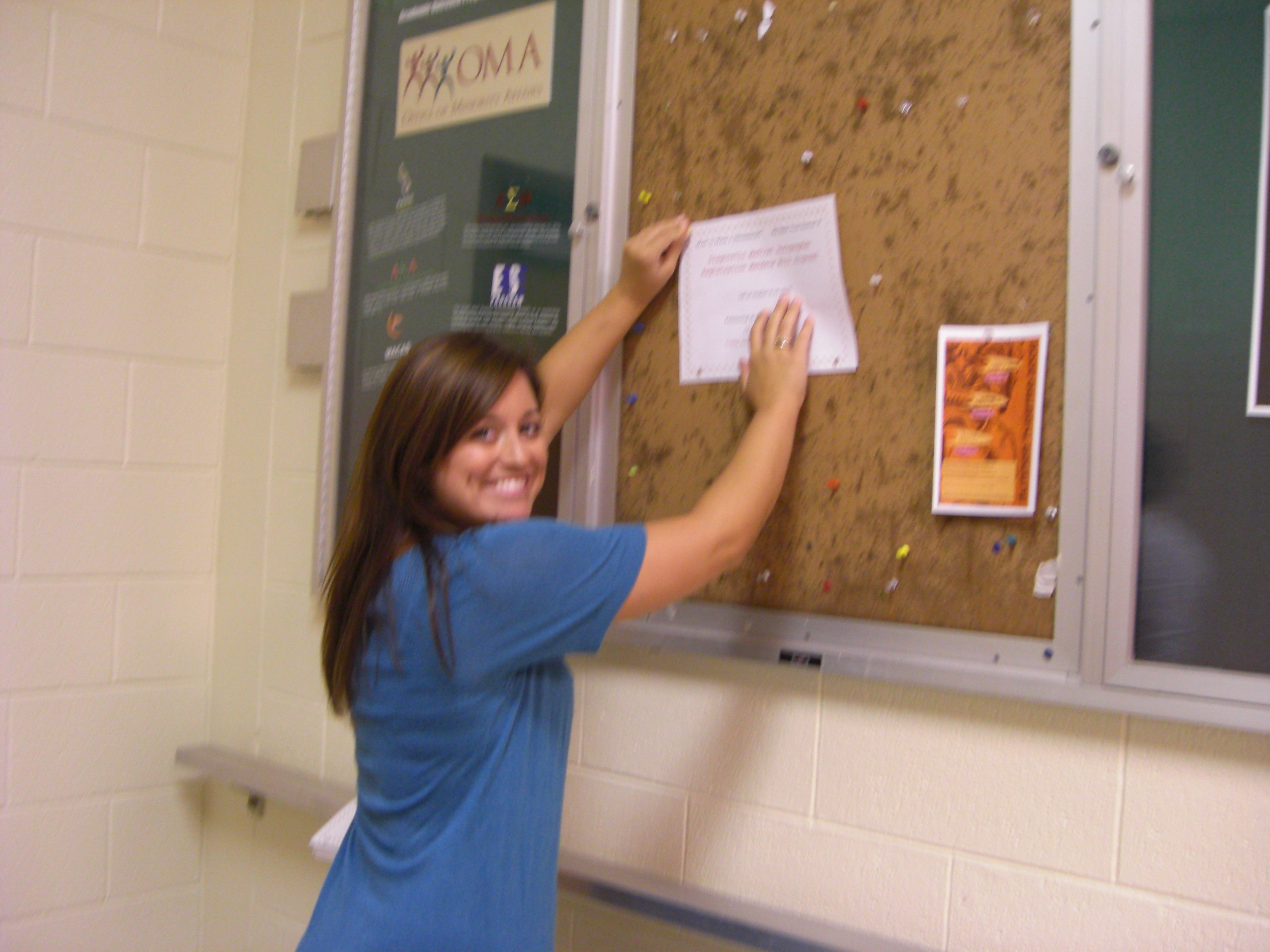 Libby hanging a flyer around AASU campus.